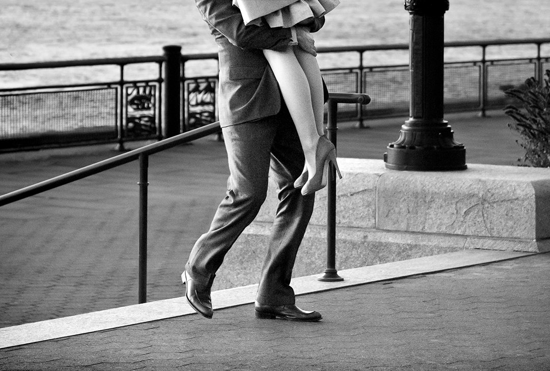 Moving legs beside a railing overlooking the water.